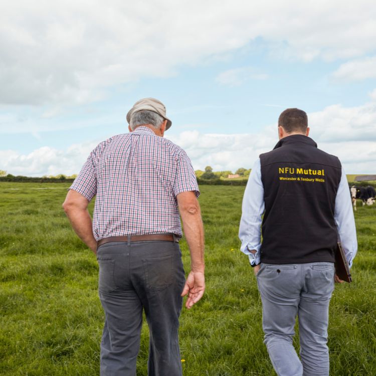 NFU Mutual agent and customer walking through a field