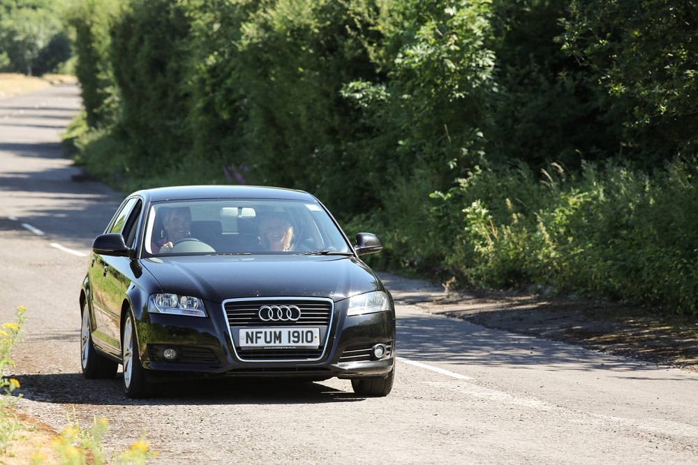 car driving along a sunny rural road